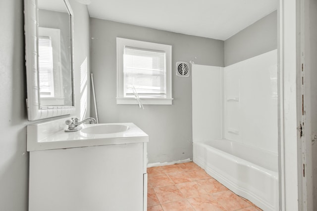 full bath featuring tile patterned flooring, visible vents, vanity, baseboards, and washtub / shower combination