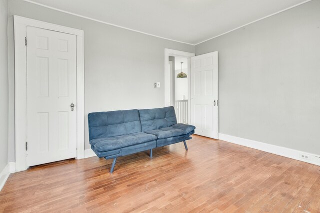 sitting room featuring baseboards, ornamental molding, and wood finished floors