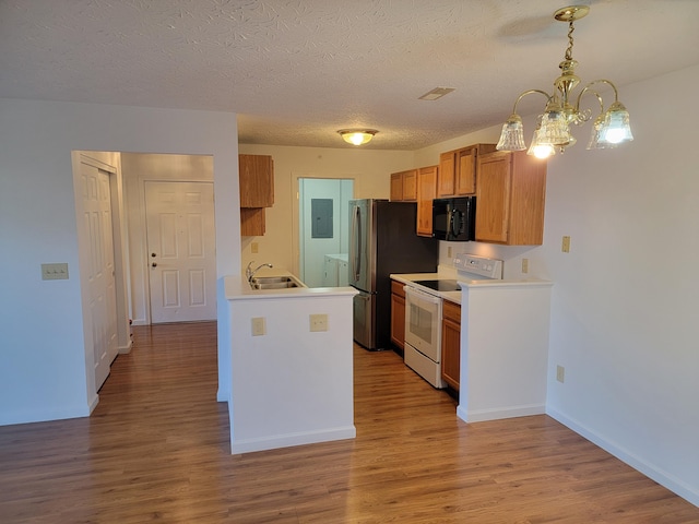 kitchen with electric stove, light countertops, wood finished floors, black microwave, and electric panel