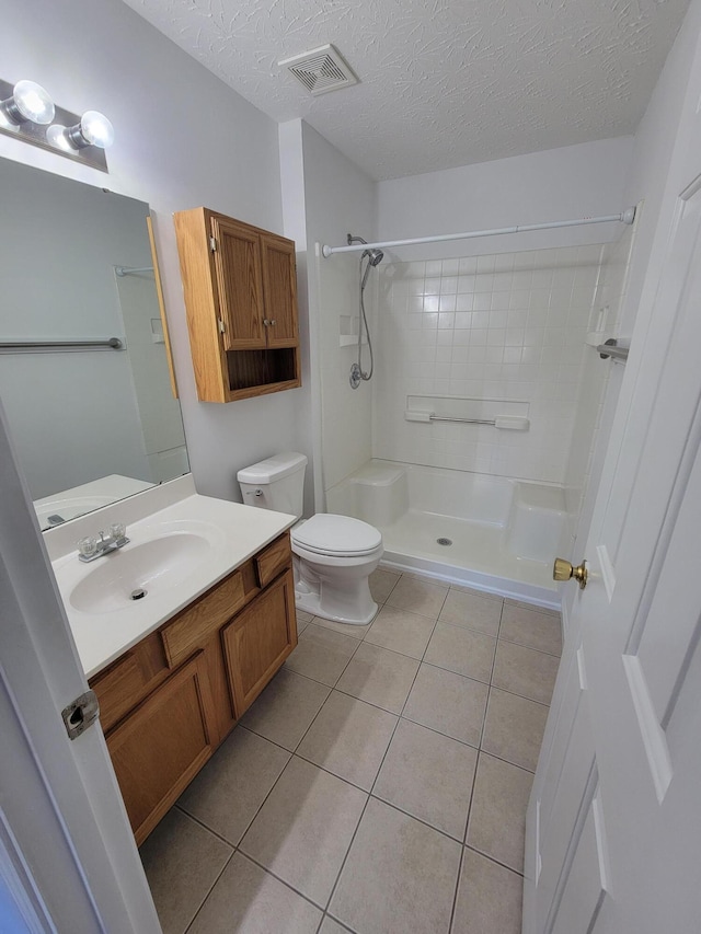 full bath featuring visible vents, toilet, tile patterned flooring, walk in shower, and a textured ceiling