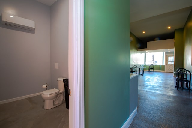 hallway featuring an AC wall unit, recessed lighting, and baseboards