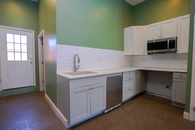 kitchen featuring white cabinetry, appliances with stainless steel finishes, backsplash, and a sink