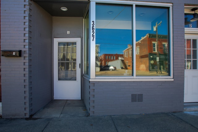 view of exterior entry featuring brick siding