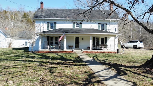 view of front of property with a chimney, a porch, and a front yard