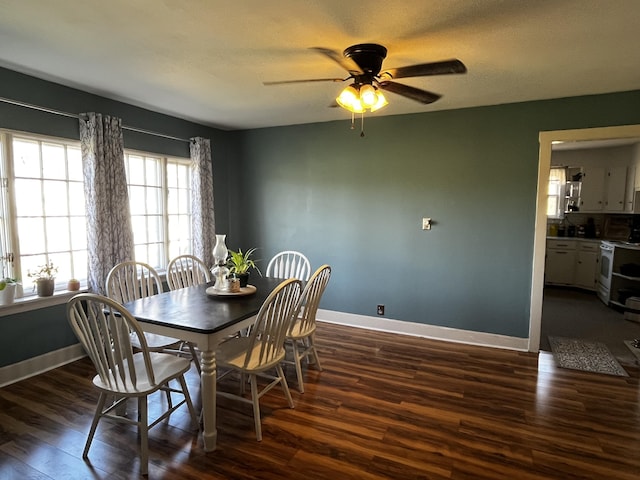 dining area featuring a textured ceiling, baseboards, dark wood finished floors, and a ceiling fan