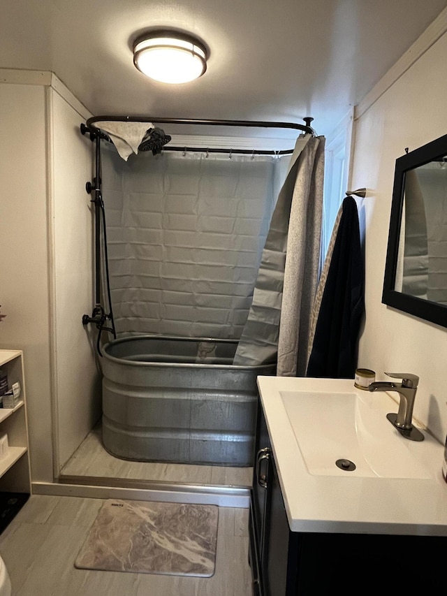 bathroom featuring shower / bath combo with shower curtain, wood finished floors, and vanity