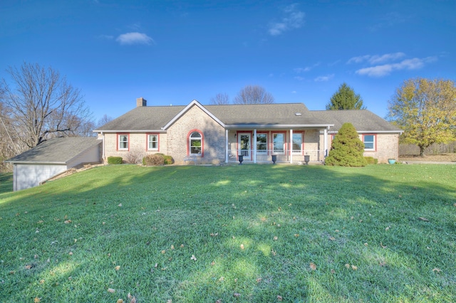 single story home featuring a chimney, a front lawn, and brick siding