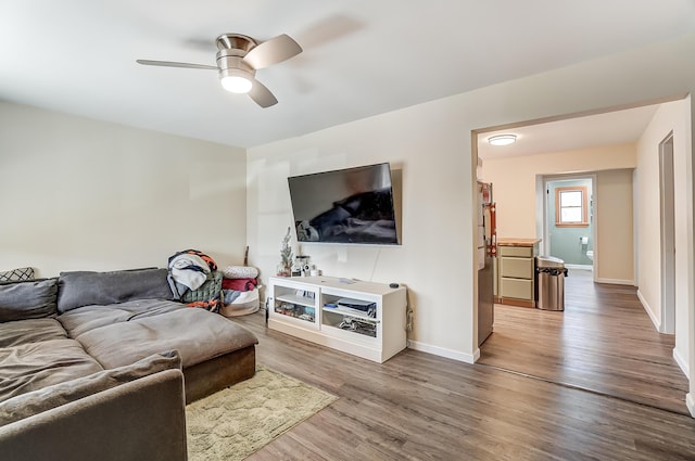 living room with ceiling fan, wood finished floors, and baseboards