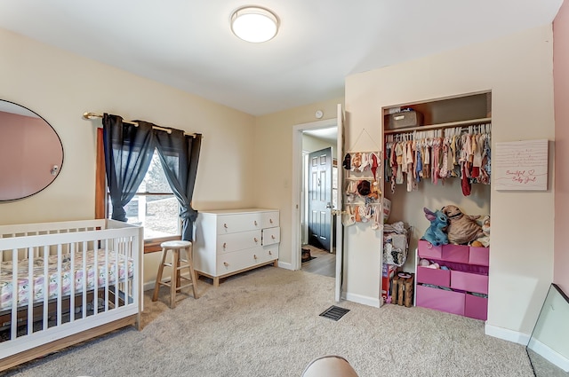 carpeted bedroom featuring visible vents, baseboards, and a closet