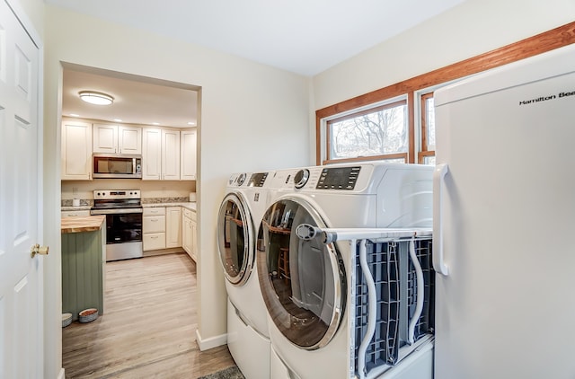 laundry room with laundry area, light wood finished floors, and separate washer and dryer