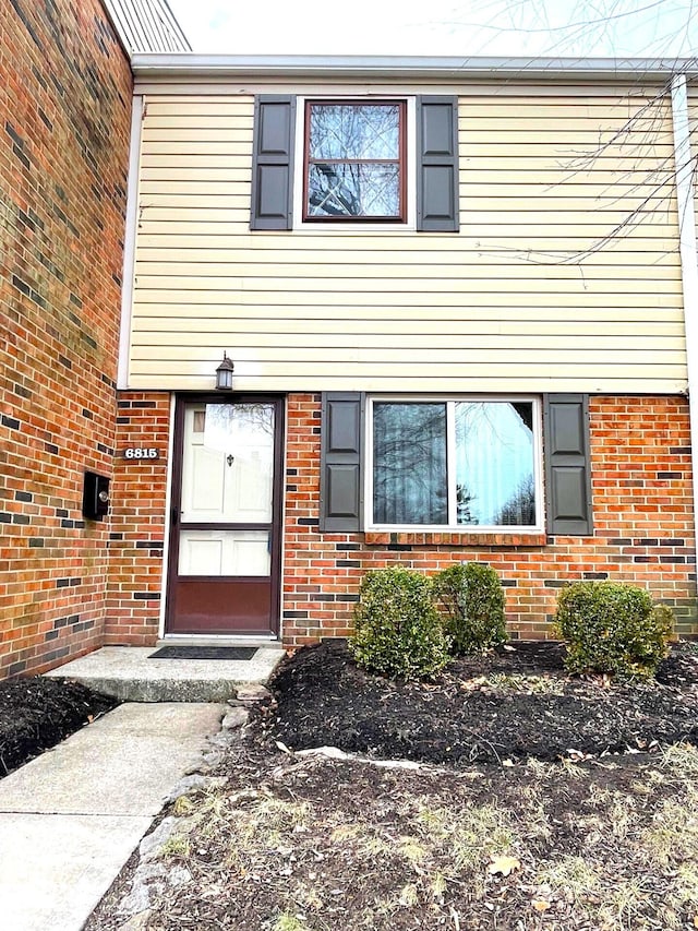 view of exterior entry featuring brick siding