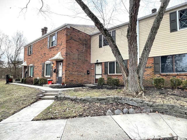 view of front of property with brick siding and a chimney