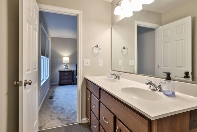 bathroom with double vanity, a sink, and baseboards