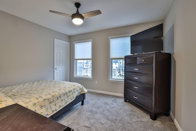 bedroom with light carpet, ceiling fan, and baseboards