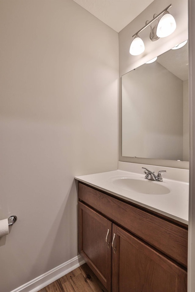 bathroom featuring baseboards, wood finished floors, and vanity