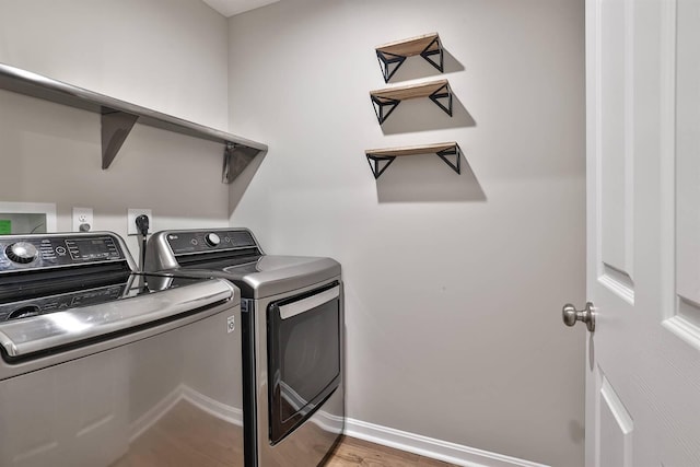 washroom featuring laundry area, independent washer and dryer, baseboards, and wood finished floors