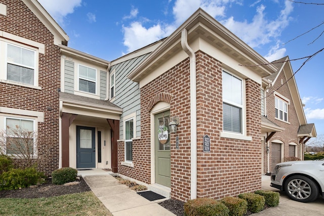 view of front of house with concrete driveway, an attached garage, and brick siding