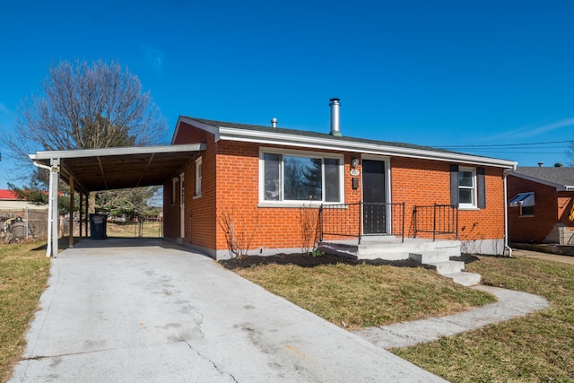 view of front facade with brick siding, concrete driveway, a front yard, fence, and an attached carport