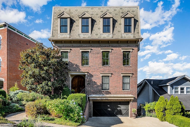 view of front facade with mansard roof, concrete driveway, and brick siding