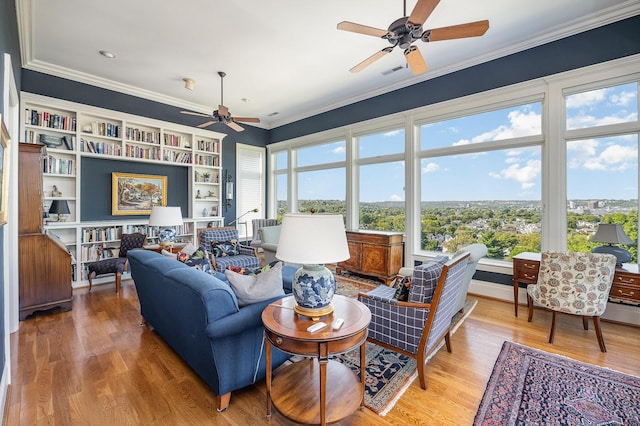 living area featuring visible vents, crown molding, and light wood finished floors