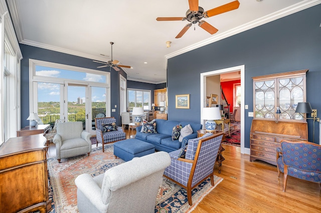 living room with ornamental molding, ceiling fan, and light wood finished floors