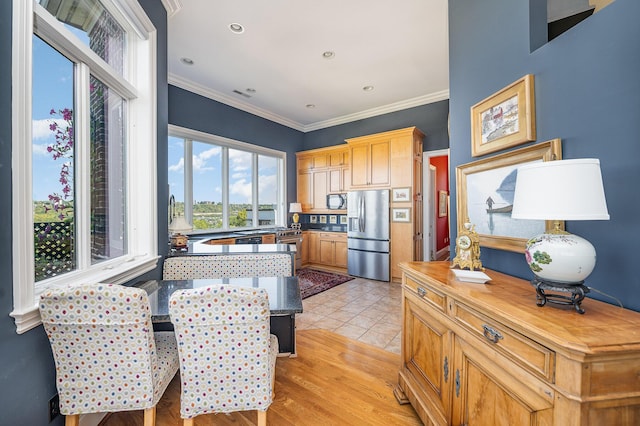 kitchen featuring stainless steel refrigerator with ice dispenser, light tile patterned floors, butcher block counters, ornamental molding, and black microwave