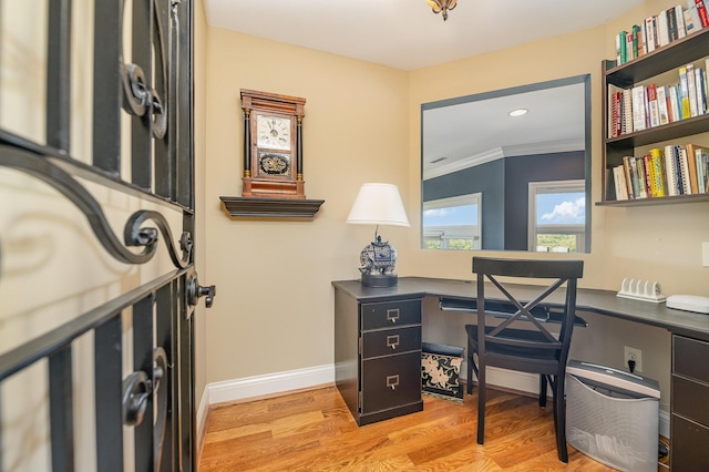 office area featuring recessed lighting, baseboards, light wood finished floors, built in desk, and crown molding