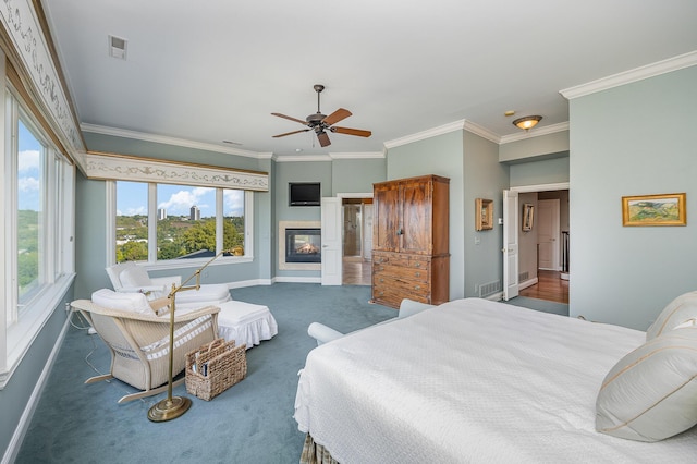 bedroom with visible vents, baseboards, dark colored carpet, a glass covered fireplace, and crown molding