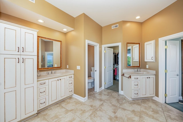 bathroom featuring toilet, baseboards, visible vents, and vanity