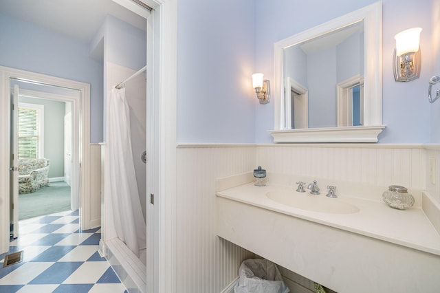 bathroom featuring curtained shower, wainscoting, visible vents, and tile patterned floors