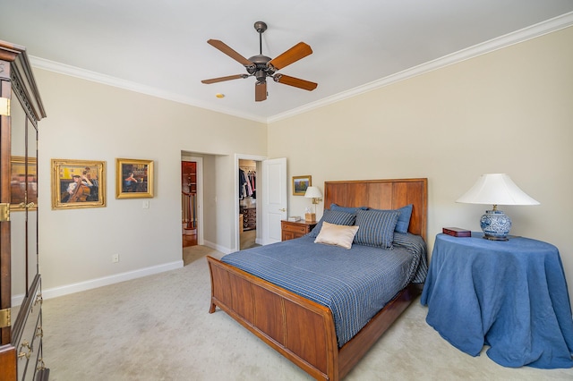 bedroom with ornamental molding, a walk in closet, light colored carpet, and baseboards