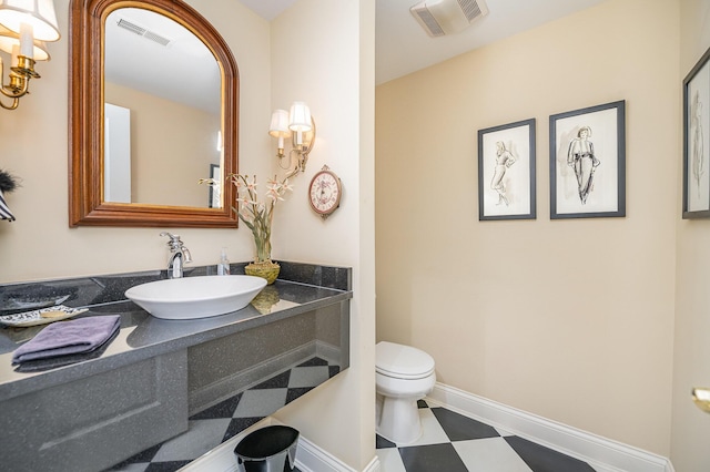 bathroom with baseboards, visible vents, vanity, and toilet