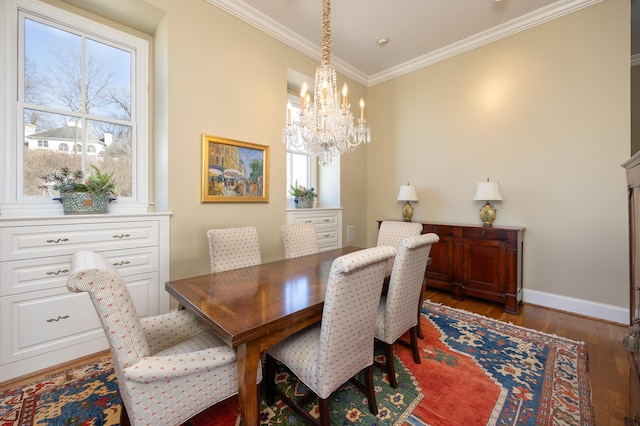 dining space with a notable chandelier, ornamental molding, wood finished floors, and baseboards