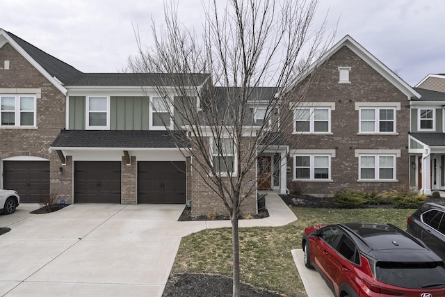 multi unit property with driveway, brick siding, board and batten siding, and an attached garage