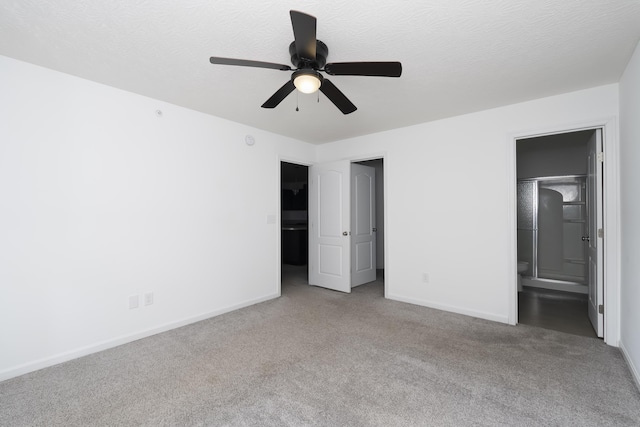 unfurnished bedroom with a textured ceiling, baseboards, and carpet flooring