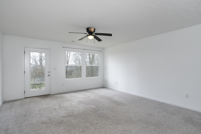 empty room featuring carpet floors, baseboards, and a ceiling fan