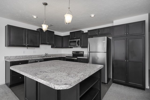 kitchen with light countertops, appliances with stainless steel finishes, hanging light fixtures, and dark cabinets