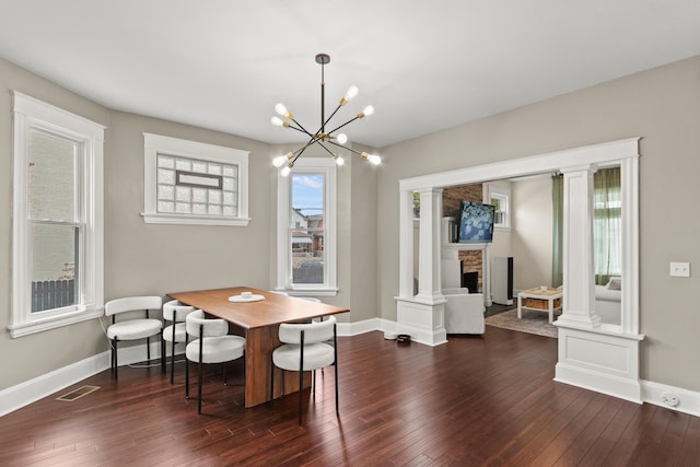 dining space featuring dark wood finished floors, visible vents, and a healthy amount of sunlight