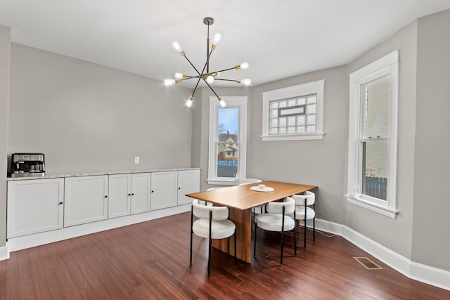 dining space with visible vents, baseboards, a chandelier, and dark wood-type flooring