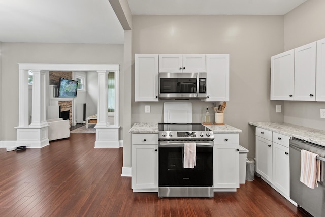 kitchen featuring appliances with stainless steel finishes, white cabinets, dark wood finished floors, and light stone countertops