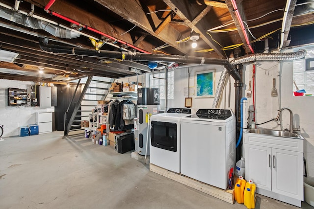 basement featuring hybrid water heater, washing machine and dryer, a sink, electric panel, and stairs