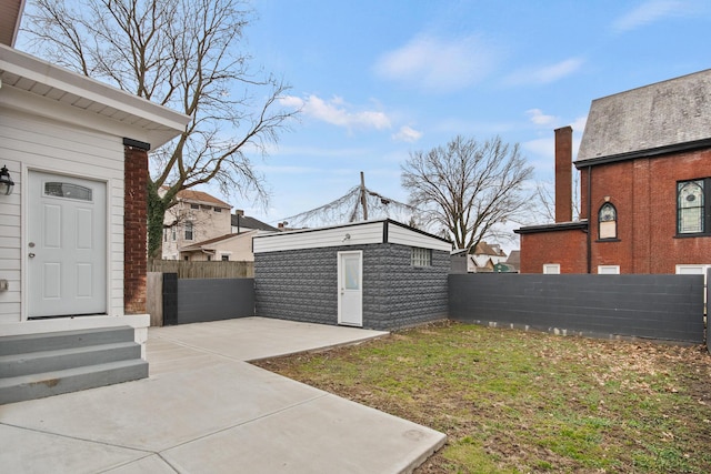 view of yard with a fenced backyard, a patio, and an outbuilding