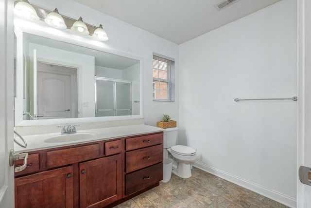 bathroom with toilet, visible vents, vanity, baseboards, and a stall shower