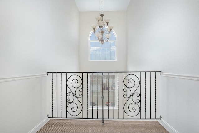 details featuring a chandelier, carpet flooring, and baseboards