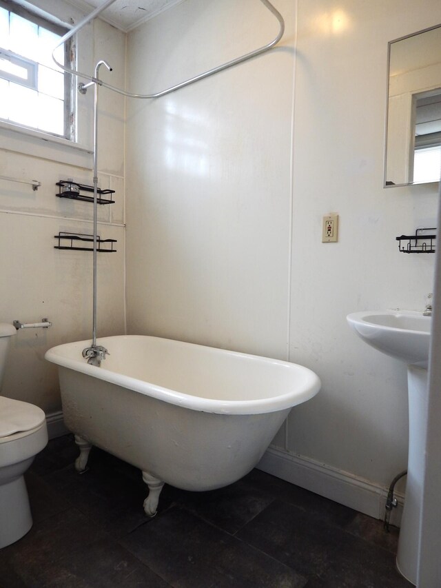 full bath with a shower, a freestanding tub, baseboards, and toilet