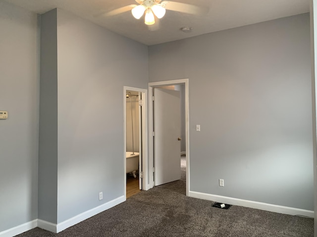 unfurnished bedroom featuring baseboards, dark carpet, and a ceiling fan