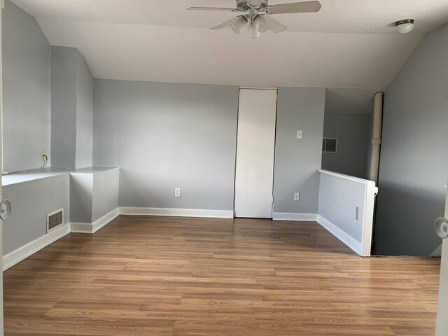 empty room featuring baseboards, a ceiling fan, visible vents, and light wood-style floors