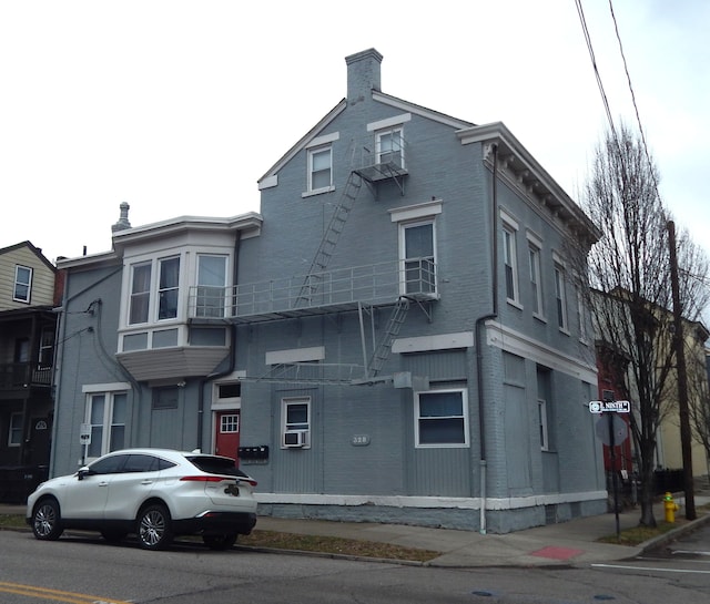 view of front of home featuring cooling unit and a chimney