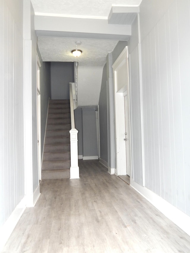 stairway featuring wood finished floors and baseboards