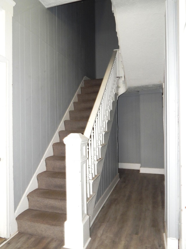 staircase featuring baseboards and wood finished floors